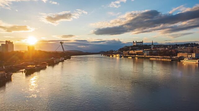 Bratislava old town and SNP bridge at sunset over of calm Danube river time lapse. Slovakia.