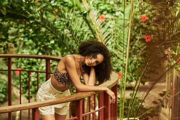 Stylish young woman in leopard print outfit enjoys tropical surroundings