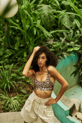 Stylish young woman showcases animal print fashion in tropical paradise setting