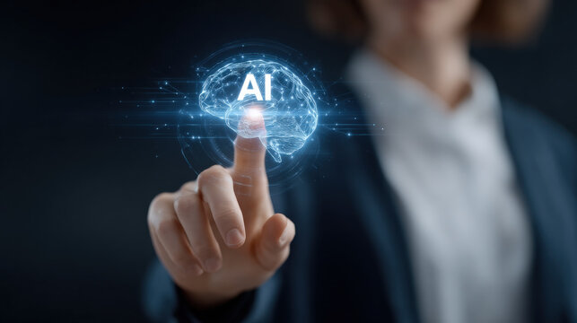 Hand touching glowing holographic representation of brain with letters AI signifies interaction between technology and artificial intelligence. This evokes sense of innovation and futuristic