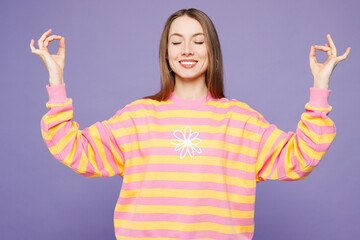 Young woman she wears yellow sweatshirt casual clothes hold spreading hands in yoga om aum gesture...