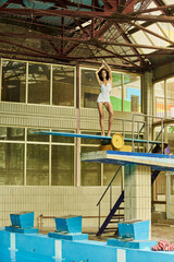 Slim young woman showcases swimwear style by the poolside during bright summer rays