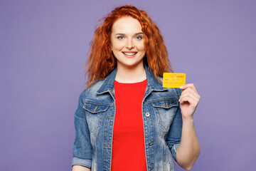 Young smiling happy fun ginger woman she wearing red t-shirt denim shirt hold in hand mock up of...