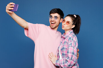 Young couple two friends family man woman in pink casual clothes sunglasses together do mobile cell...
