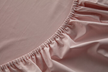 A close-up view of soft, pale pink fabric reveals a gathered texture that adds depth and interest,...