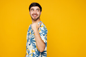 Side view young Caucasian man he wearing blue beach t-shirt casual clothes point thumb finger back...