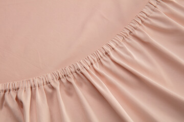 A close-up view of soft, pale pink fabric reveals a gathered texture that adds depth and interest,...