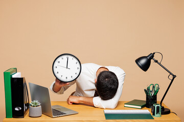 Young sleepy tired exhausted sad employee business man wear white shirt tie sit work put head on...