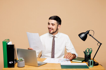 Young smiling happy successful employee business man wear white shirt tie sit work at office desk...