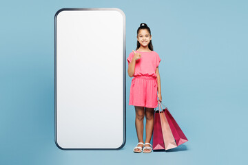 Little kid girl 9-10 years old wear pink clothes hold package bags after shopping big huge blank...