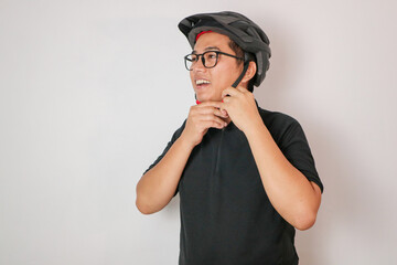 Asian men putting on a safety helmet in order to use his alternative, eco-friendly vehicle to travel from her office to home