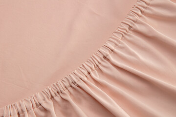 A close-up view of soft, pale pink fabric reveals a gathered texture that adds depth and interest,...