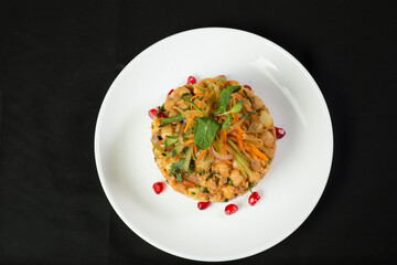 Spicy Chana Chaat with onion, tomato, carrot, cucumber and pomegranate seeds in plate isolated on dark background top view of Colorful Indian Chickpea Salad