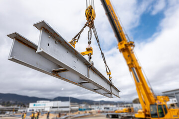 Fototapeta premium Close up, A crane lifting heavy steel beams at site