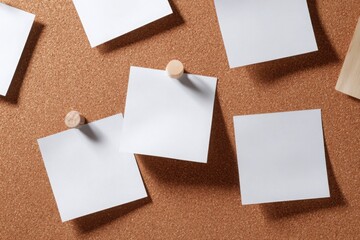 Empty white sticky notes arranged in two rows of three on a cork bulletin board, ideal for planning, reminders, or presentations.