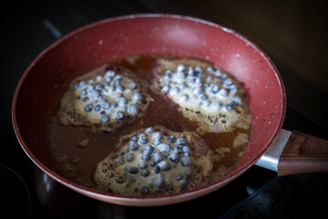 baking tyrolean blueberry pancakes in a pan with butter, a traditional austrian cuisine
