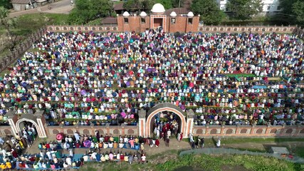 Dinajpur, Bangladesh - 24 August 2025: Aerial view of a vast gathering of people praying at Eidgah, creating a vibrant mosaic of colors under the open sky.
