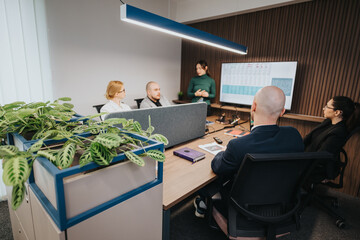 A group of colleagues collaborates during an office meeting, focusing on discussions and...
