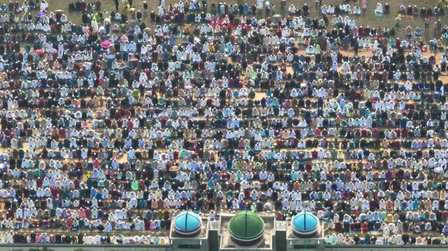 Dinajpur, Bangladesh - 24 August 2025: Aerial view of a vast crowd gathered in orderly rows, creating a sea of humanity with colorful clothing.