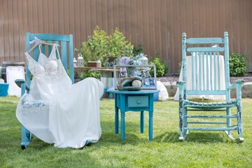 Rustic outdoor wedding scene with dress and memorabilia.