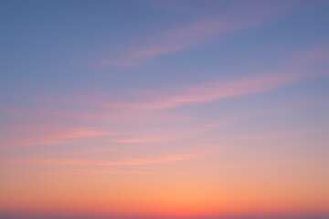 Obraz premium Soft Pink and Orange Clouds in a Pastel Sunset Sky image photo