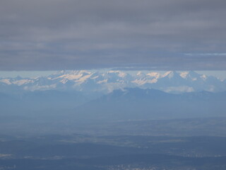 Alps, Europe &ndash; : Snow-capped Alpine mountains and clouds seen from airplane window during flight between Ljubljana and Zurich