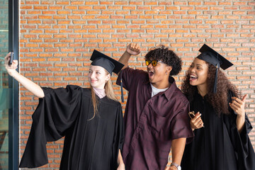 Graduates taking celebratory selfie on graduation day