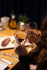 Clinking glasses of white wine during elegant dinner