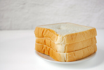 White sliced bread stacked on the white wooden table