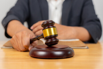 Close-up of a gavel with a judge in the background, symbolizing law, legal proceedings, justice, and courtroom authority