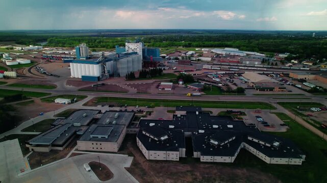 Tanker truck past a grain elevator and rail yard, capturing the heart of America's agricultural supply chain.