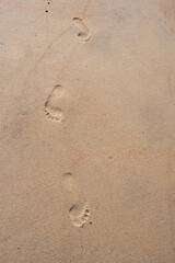 Footprints on wet sand beach footsteps walking outdoors holiday seaside beige ochre background sandy