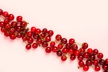 Many red sweet cherries on pink background