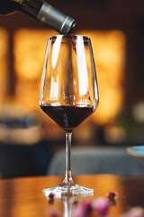 Close-up of red wine pouring into crystal wine glass