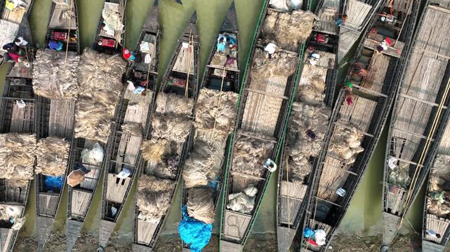 Jamalpur, Bangladesh - 23 August 2025: Aerial view of boats laden with goods creating a textured mosaic on the water, a hive of activity under the sun.