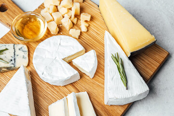 Cheese platter featuring various types of cheese and honey on a wooden board