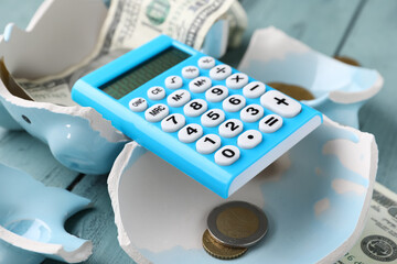 Calculator on broken piggy bank with coins
