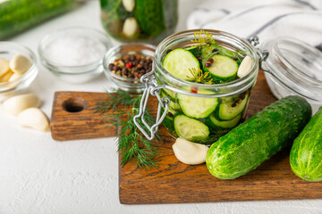 Freshly-salted homemade cucumbers in a jar on a wooden background. pickled cucumbers with dill,garlic and pepper.canned cucumbers.cucumbers and dill.Recipe of homemade preservations.fermented veggies.