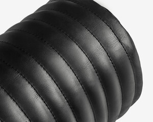 Black leather upholstery forming elegant parallel lines, creating luxurious texture