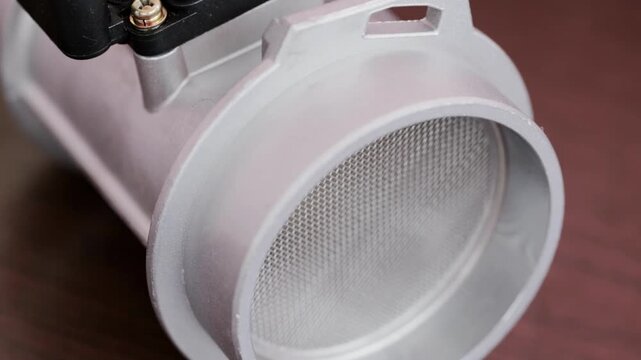 Modern electronic mass air flow sensor on brown paper, close-up. Car spare part, industry, close-up