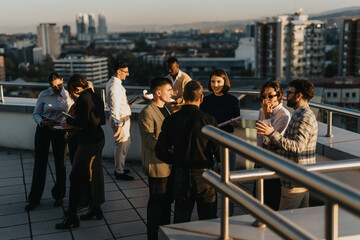 A group of business colleagues gather on a high tower balcony, collaborating and brainstorming...