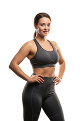 Obraz premium Confident fit woman in grey sportswear stands with hands on hips, smiling. Athletic female model and personal trainer portrait Isolated on a Transparent Background for health and wellness advertising