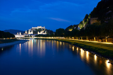 Fototapeta premium Cityscape of Salzburg at dusk, with the historic Hohensalzburg Fortress on hilltop, Austria