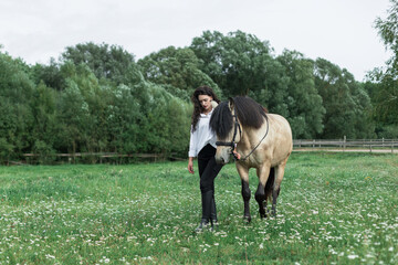 Young woman with horse in countryside meadow, showing equestrian bond, trust, rural lifestyle,...
