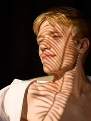 Male face with shadow lines creating artistic skincare concept. Concept of style, self-care, mental balance, identity, men grooming, and cosmetic advertising.