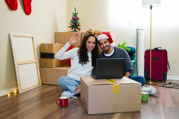 Happy couple of homeowners video calling family celebrating first christmas in new home