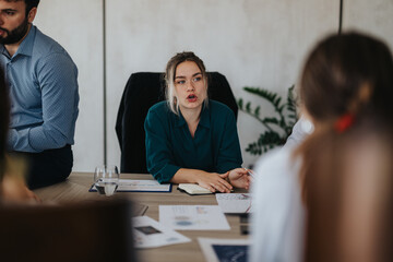 A diverse group of business people engaged in a serious meeting, discussing plans and strategies...