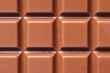 Tasty milk chocolate bar as background, closeup