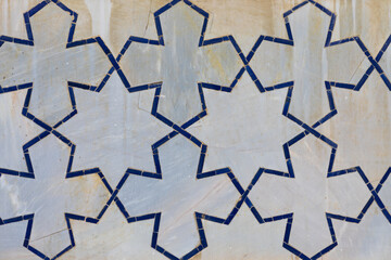 Background with geometric arabic girih pattern. Blue ceramic tile pattern on white marble