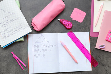 Copybooks with math formulas and bright stationery on dark background